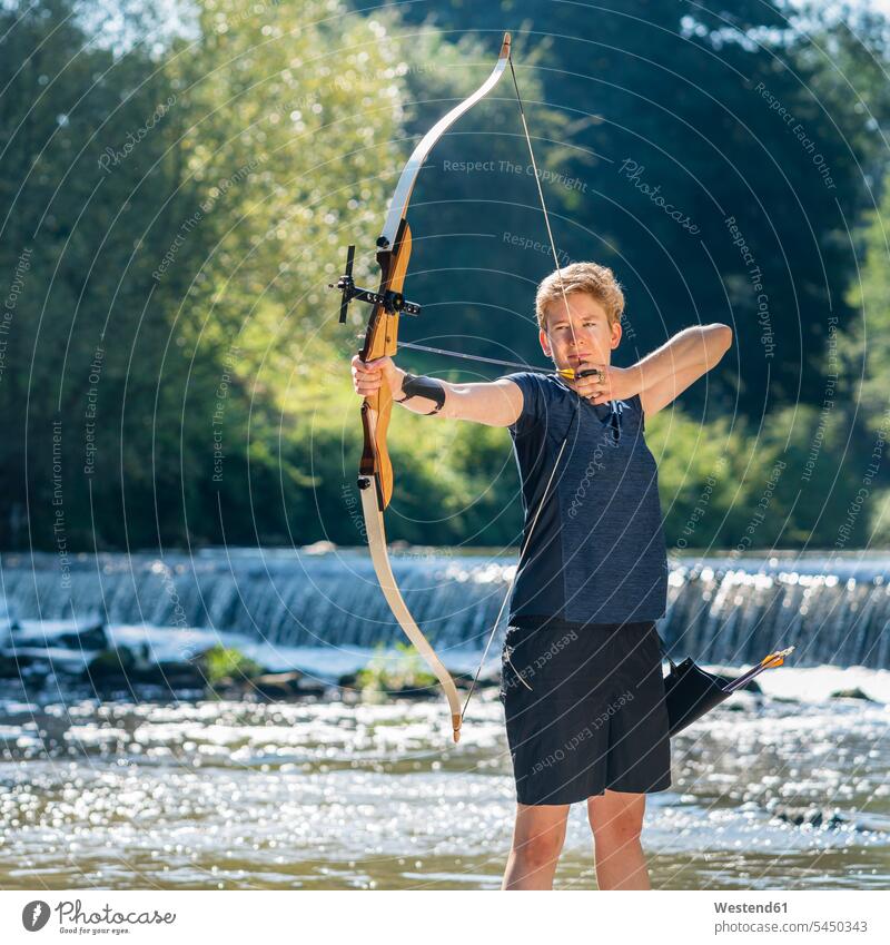 Portrait of archeress aiming with her bow archery woman females women shooting sports Adults grown-ups grownups adult people persons human being humans