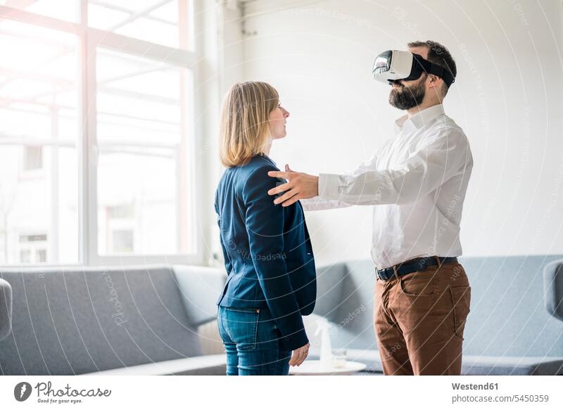 Businessman with VR glasses in office touching businesswoman businesswomen business woman business women Business man Businessmen Business men specs Eye Glasses