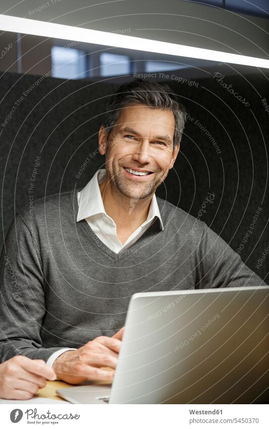 Portrait of smiling businessman with laptop in meeting box office offices office room office rooms portrait portraits smile Laptop Computers laptops notebook