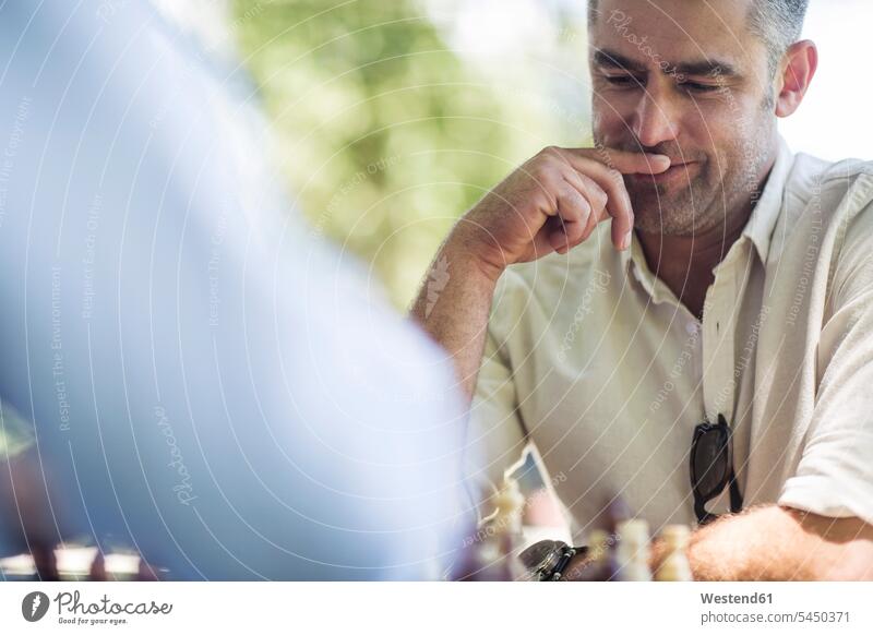Man playing game of chess thinking cogitate man men males Adults grown-ups grownups adult people persons human being humans human beings board game board-games