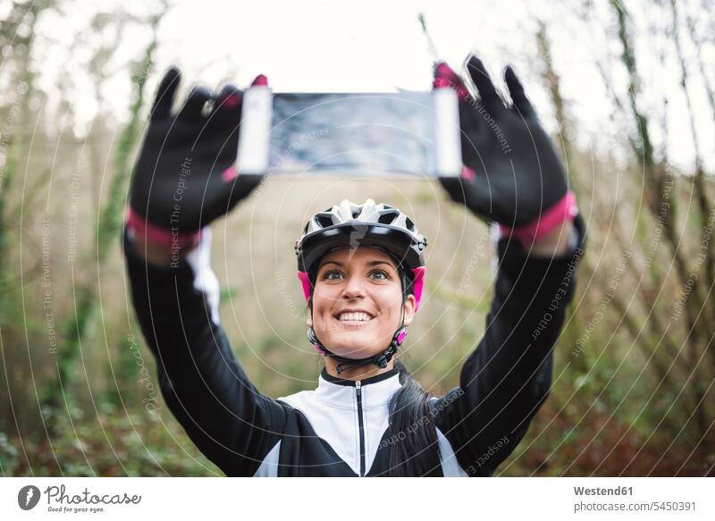 Smiling female mountain biker taking a selfie Selfie Selfies woman females women smiling smile cycling helmet Bike Helmet bicycle helmet bicycle helmets