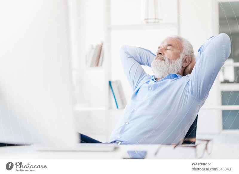 Mature man with beard relaxing at desk men males break relaxed relaxation Adults grown-ups grownups adult people persons human being humans human beings