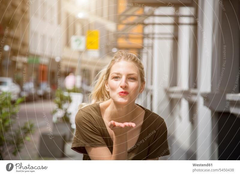 Portrait of happy blond woman blowing a kiss blow kiss portrait portraits females women Adults grown-ups grownups adult people persons human being humans