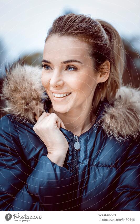 Portrait of smiling woman wearing winter jacket with fur collar smile portrait portraits females women Adults grown-ups grownups adult people persons