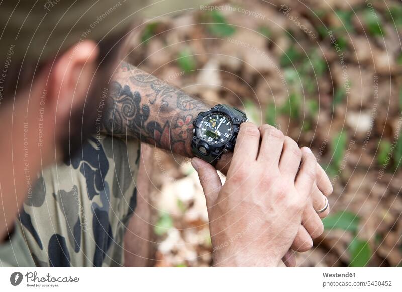 Close-up of man in forest checking the time wrist watch Wristwatch Wristwatches wrist watches tattoo tattoos men males woods forests tattooed style stylish