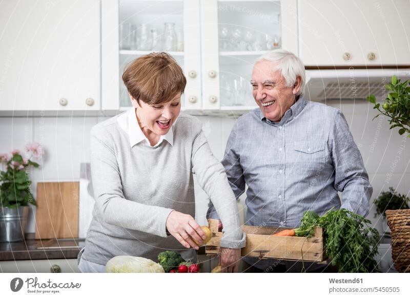 Senior couple standing in kitchen, unpacking fresh vegetables caucasian caucasian ethnicity caucasian appearance european Joy enjoyment pleasure Pleasant