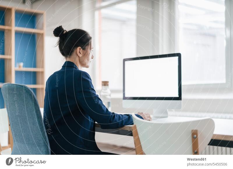 Woman working at desk in a loft computer computers woman females women Adults grown-ups grownups adult people persons human being humans human beings office