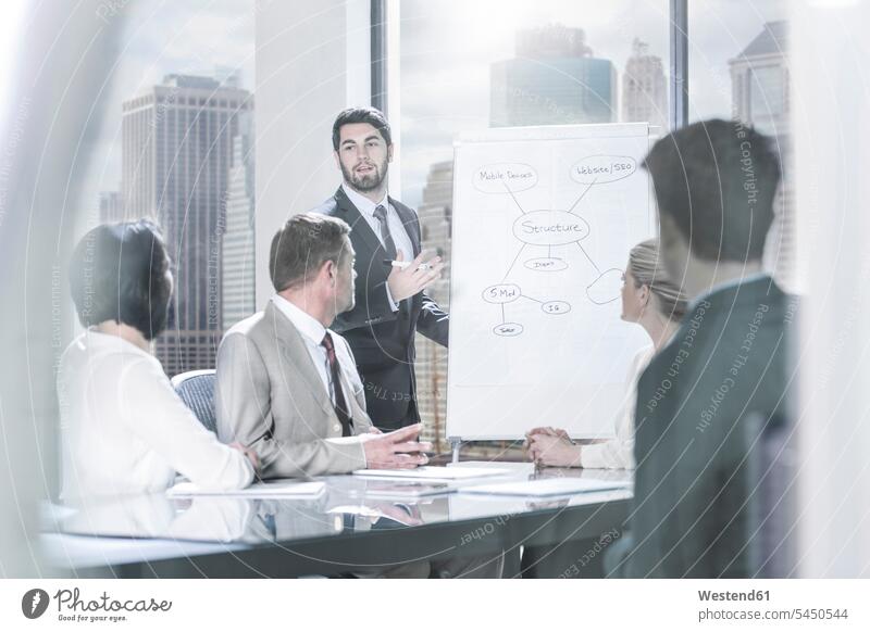 Businessman leading a presentation in city office offices office room office rooms presentations group of people Group groups of people Business Meeting