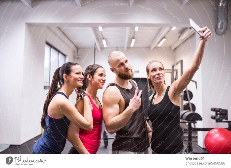 Group of young athetes taking selfies in gym sharing share athlete sportswoman athletes female athlete sportswomen female athletes gyms Health Club Selfie
