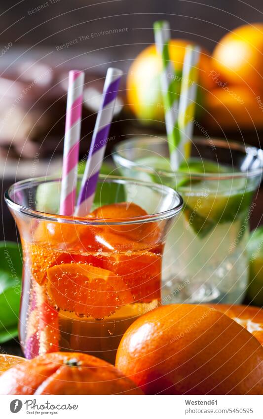 Fruit spritzer of tangerines and lime in a glass with drinking straws juicy healthy eating nutrition focus on foreground Focus In The Foreground