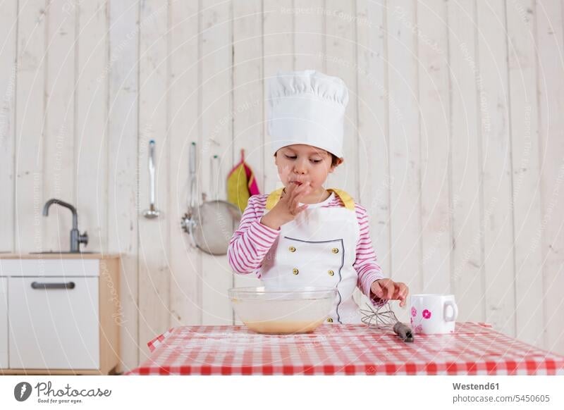 Little girl preparing waffles, wearing chef's hat baking bake dough standing kitchen females girls Food foods food and drink Nutrition Alimentation