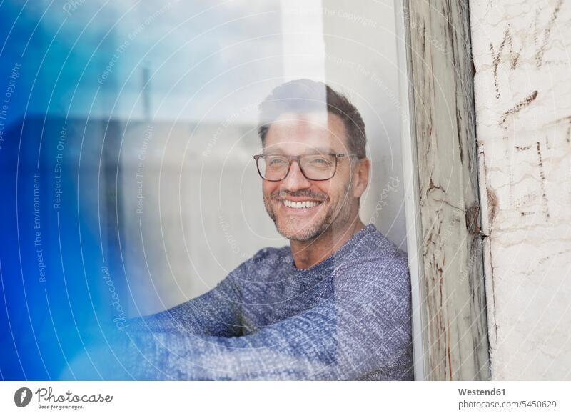 Portrait of laughing man behind glass pane wearing glasses men males portrait portraits specs Eye Glasses spectacles Eyeglasses Laughter window windows