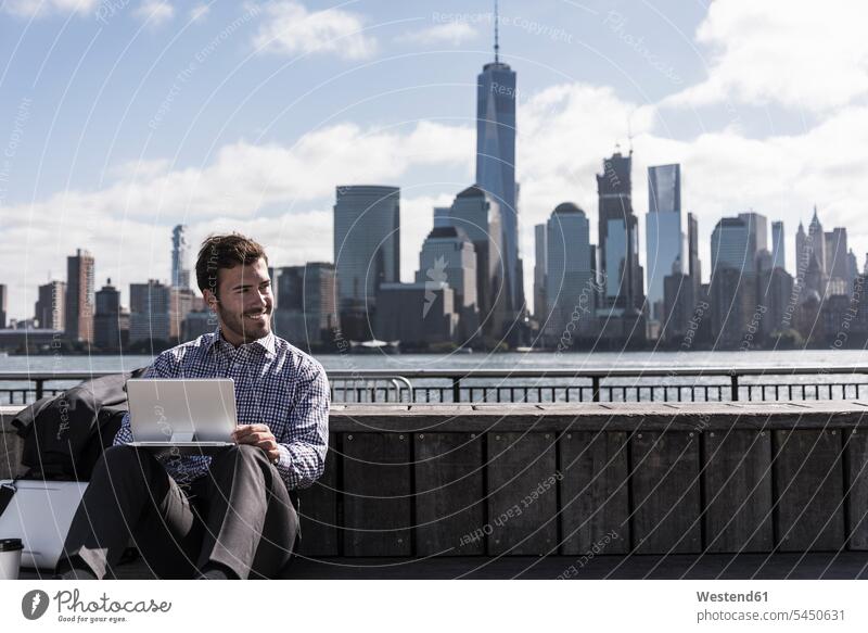 USA, man using tablet at New Jersey waterfront with view to Manhattan smiling smile New York State digitizer Tablet Computer Tablet PC Tablet Computers iPad