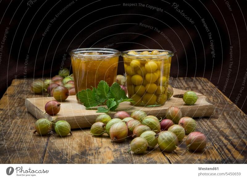 Jar of gooseberry jam, gooseberries and glass of preserved gooseberries on wood nobody large group of objects many objects uncooked fruit homemade home made