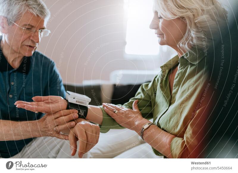 Senior couple taking blood pressure at home senior men senior man elder man elder men senior citizen twosomes partnership couples senior adults males Adults