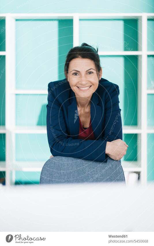 Portrait of smiling businesswoman in office businesswomen business woman business women portrait portraits females business people businesspeople business world