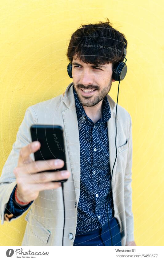 Portrait of young man with headphones and cell phone headset men males Adults grown-ups grownups adult people persons human being humans human beings portrait