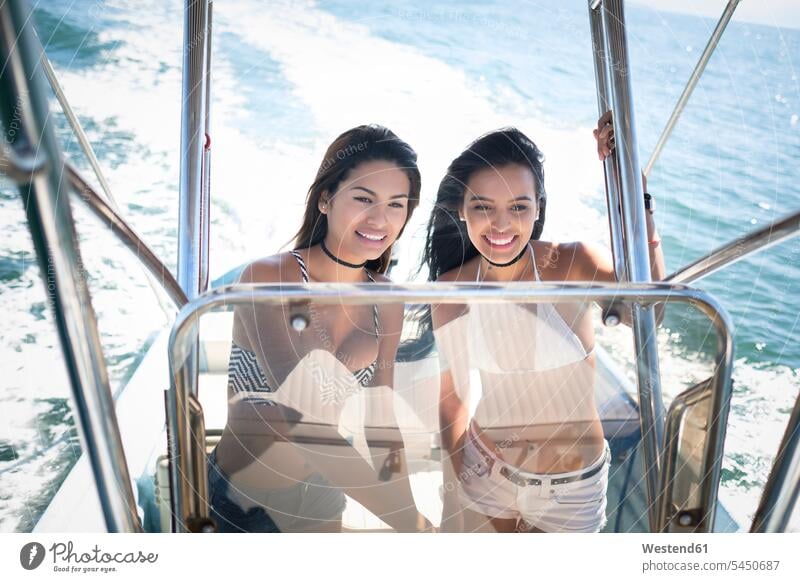 Two young women on a boat trip female friends casual leisure wear casual clothing casual wear casual clothes Casual Attire three-quarter length