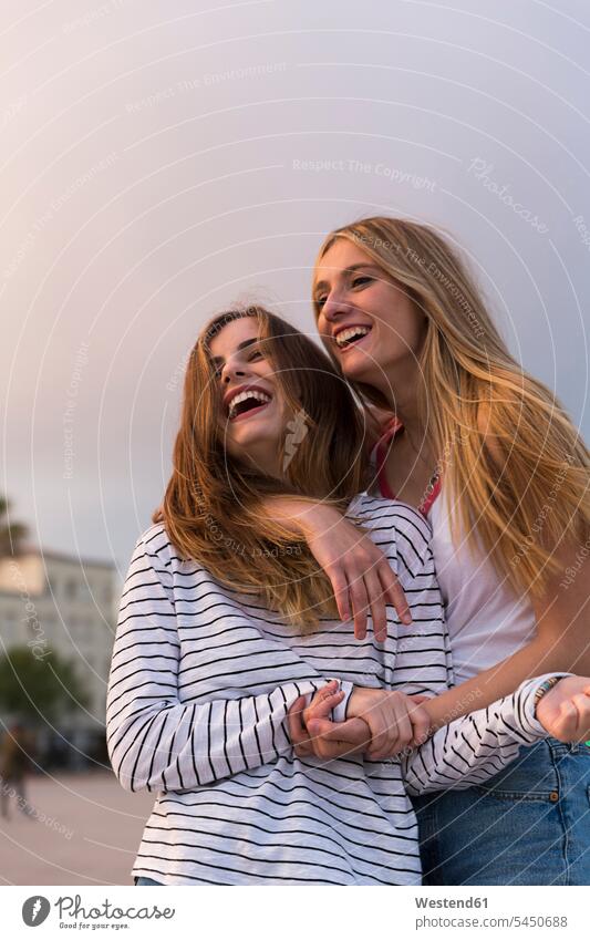 Portrait of two laughing young women female friends mate friendship woman females Laughter Adults grown-ups grownups adult people persons human being humans