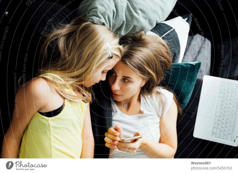 Relaxed mother and daughter with cell phone on sofa home at home mobile phone mobiles mobile phones Cellphone cell phones relaxed relaxation mommy mothers ma