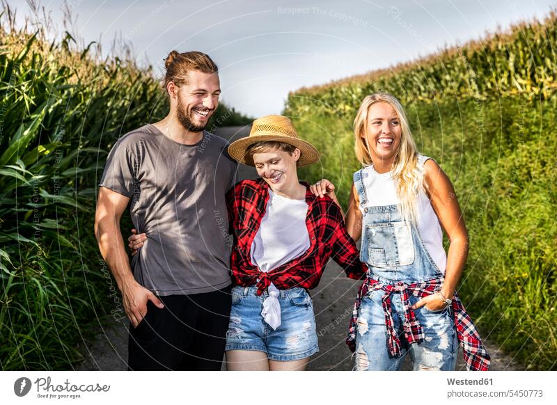 Happy friends on country lane at a cornfield Field Fields farmland rural countryside mate relaxed relaxation laughing Laughter Grain field Cornfield Corn Field