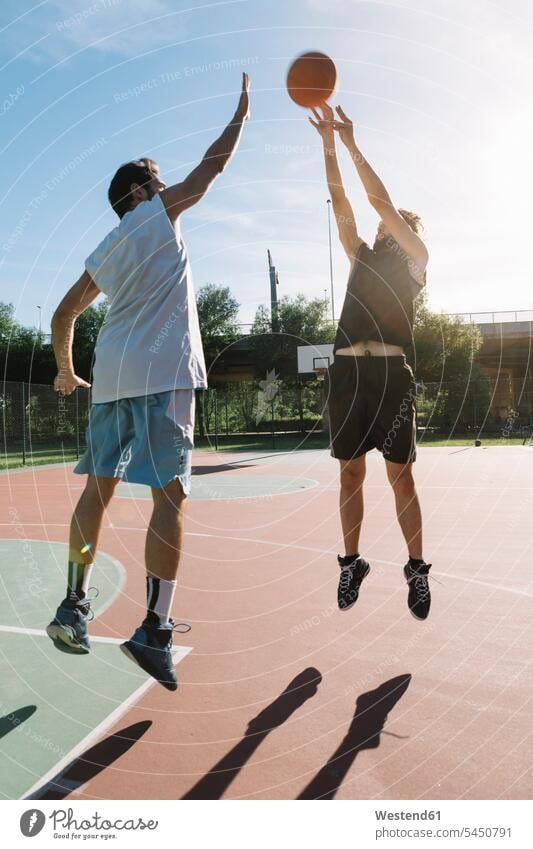 Men playing basketball leisure free time leisure time sport sports man men males jumping Leaping basketball player basketball players throwing basketballs