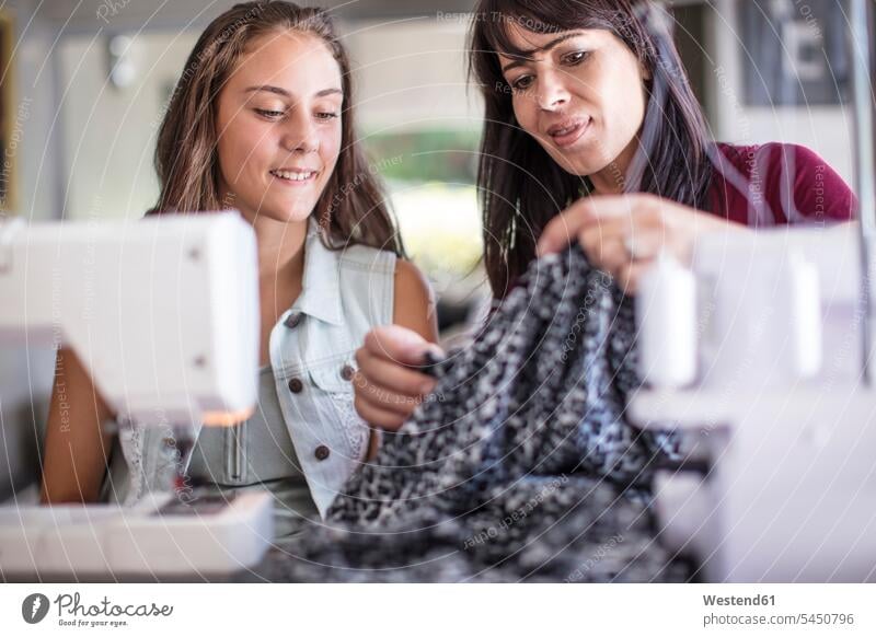 Mother and daughter sewing together sewing machine sewing machines daughters learning mother mommy mothers mummy mama Electrical Equipment Electrical Equipments