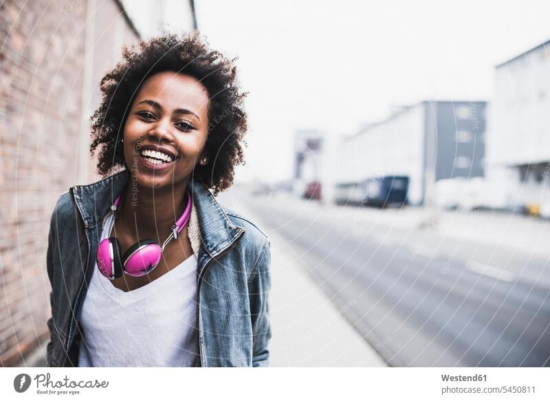 Portrait of smiling young woman with headphones portrait portraits females women Adults grown-ups grownups adult people persons human being humans human beings