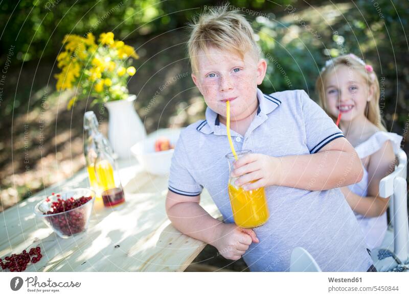 Sister and brother drinking homemade lemonade at garden table brothers Lemonade sister sisters siblings brother and sister brothers and sisters family families
