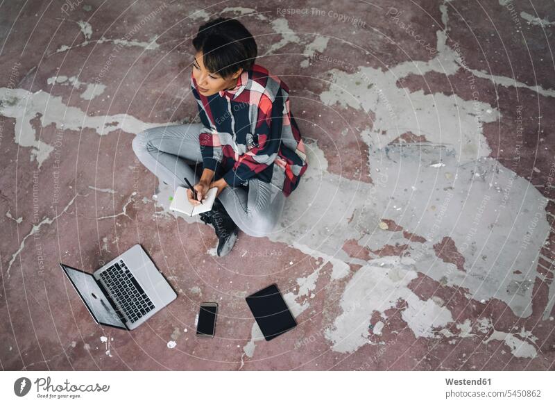 Woman sitting on cracked floor with notebook writing write laptop Laptop Computers laptops notebooks businesswoman businesswomen business woman business women
