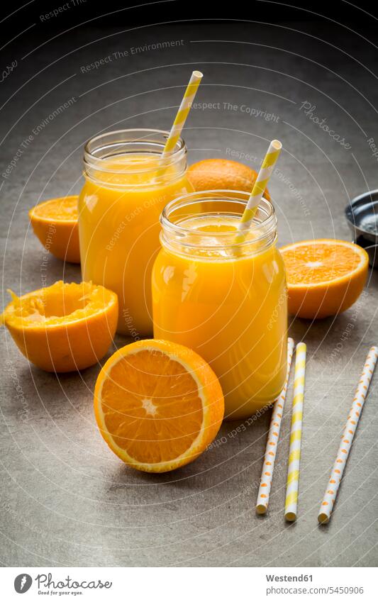 Oranges, glasses of freshly squeezed orange juice whole sliced straw straws drinking straw drinking straws half halves halved Glass Drinking Glasses fruit skin