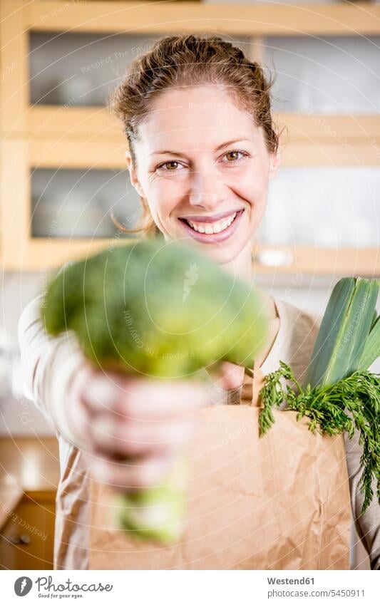 Portrait of happy woman holding broccoli Broccoli Broccolis females women happiness Cabbage Wild Cabbage Cabbages Vegetable Vegetables Food foods food and drink