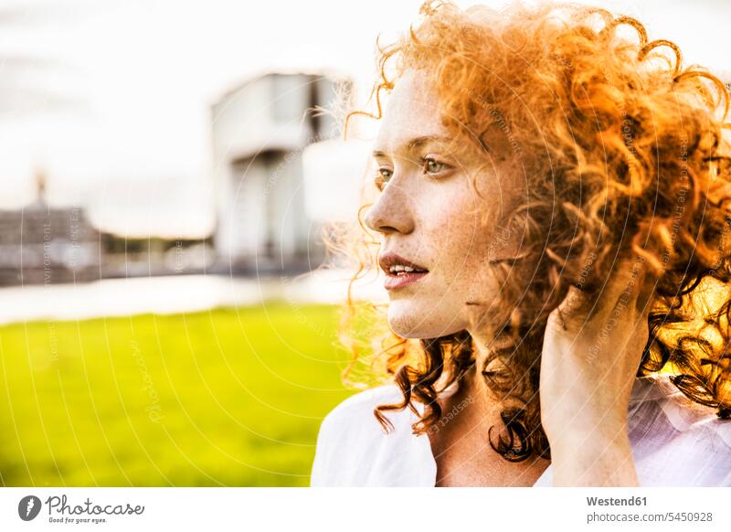 Germany, Cologne, portrait of freckled young woman with curly red hair portraits females women curly hair curls Adults grown-ups grownups adult people persons