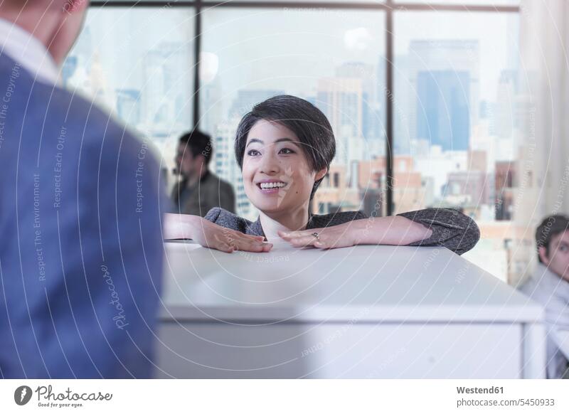Woman talking to colleague in city office colleagues offices office room office rooms speaking smiling smile workplace work place place of work business