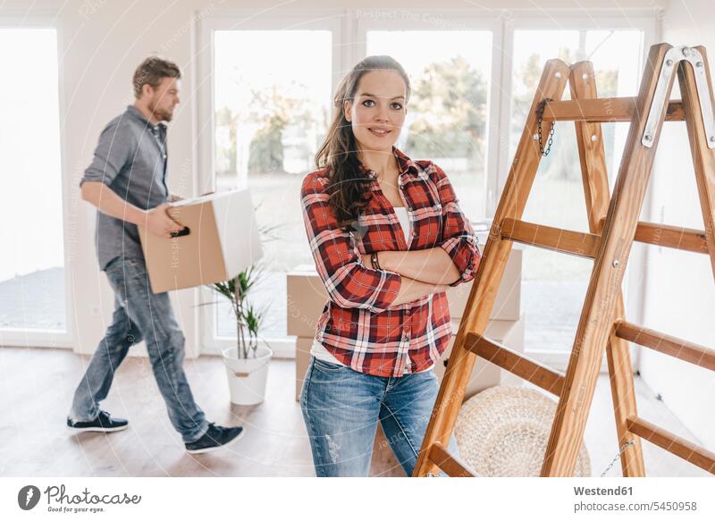 Couple moving house, carrying boxes in new home owner owners move Moving Home flat flats apartment apartments property couple twosomes partnership couples