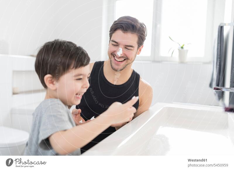 Playful son applying shaving foam on father's nose Fun having fun funny pa fathers daddy dads papa laughing Laughter sons manchild manchildren parents family