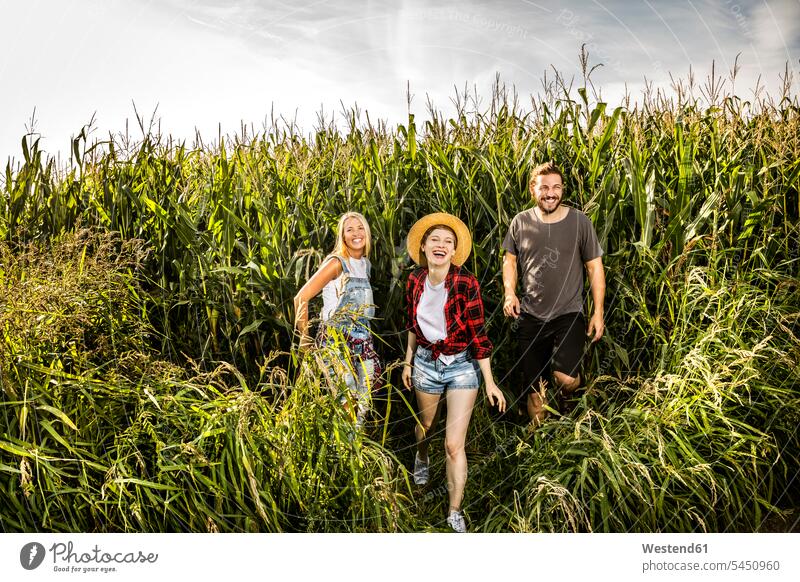 Happy friends in a cornfield relaxed relaxation rural country countryside mate smiling smile Field Fields farmland laughing Laughter relaxing friendship