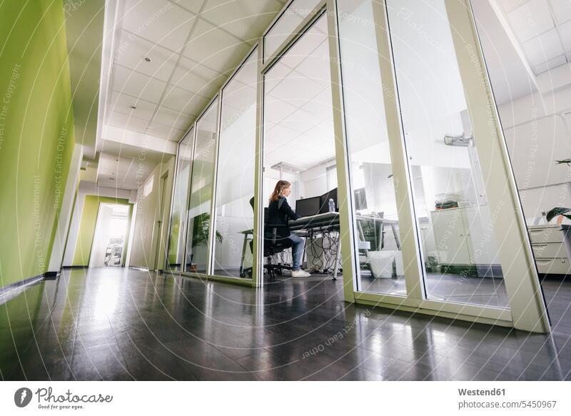 Woman working in modern office offices office room office rooms businesswoman businesswomen business woman business women At Work sitting Seated Corridor