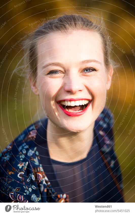 Portrait of laughing young woman in autumn fall females women portrait portraits Adults grown-ups grownups adult people persons human being humans human beings