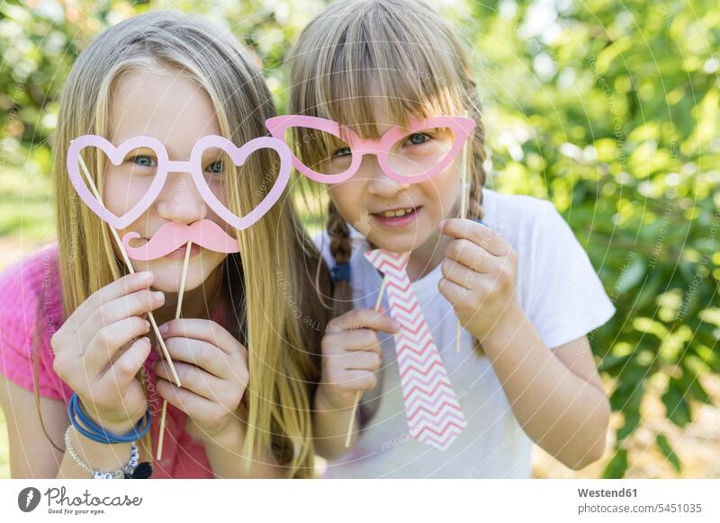 Two playful sisters in garden Fun having fun funny playing happiness happy glasses specs Eye Glasses spectacles Eyeglasses gardens domestic garden girl females