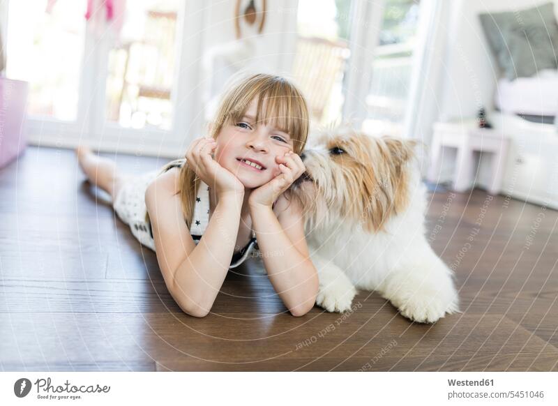 Girl with dog lying on the floor at home happiness happy girl females girls smiling smile dogs Canine laying down lie lying down child children kid kids people