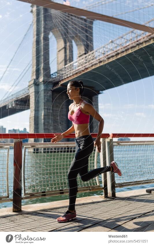 Woman training in the morning in Manhattan near Brooklyn Bridge exercising exercise practising fast quick speediness rapidity rapidness apace running jogger