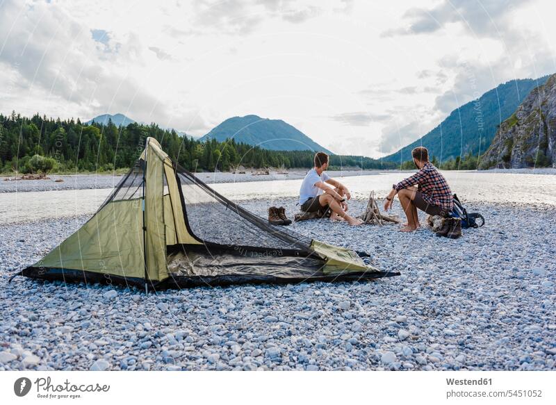 Germany, Bavaria, two hikers camping on gravel bank looking at view friends friendship tent tents watching trekking sitting Seated seeing viewing River Rivers