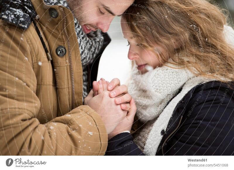 Happy young couple holding hands winter hibernal fidelity faithfulness loyalty twosomes partnership couples hand in hand in love people persons human being