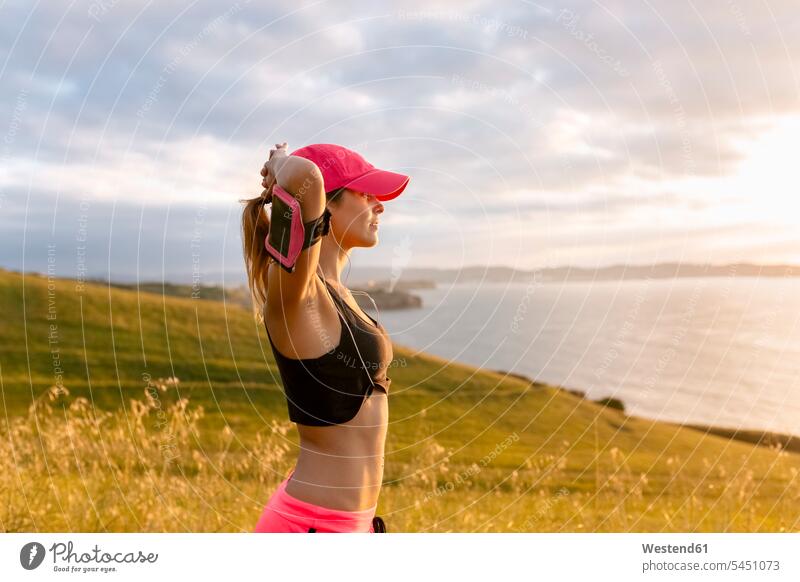 Young woman looking at the sea after workout exercising exercise training practising females women Adults grown-ups grownups adult people persons human being