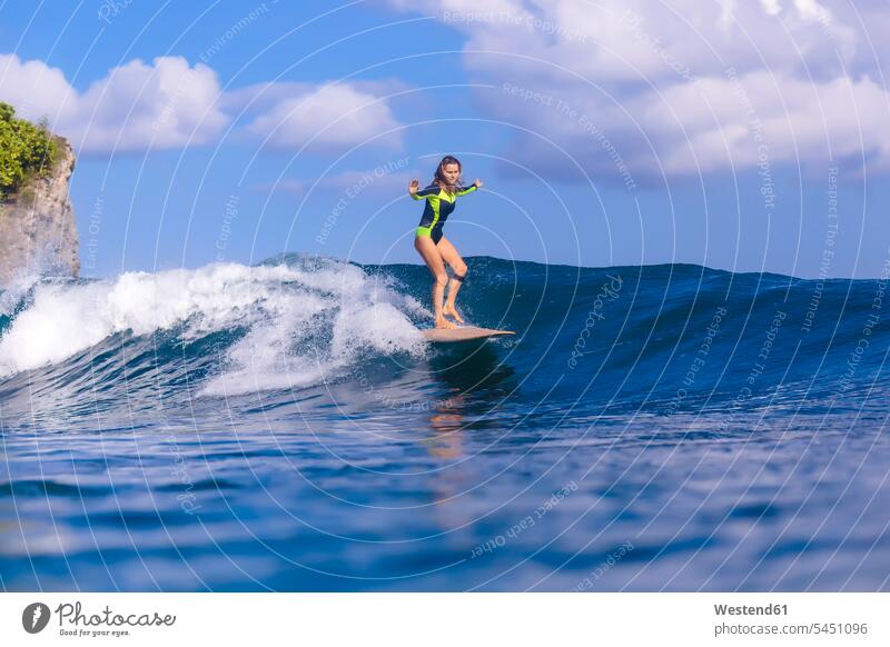 Indonesia, Bali, woman surfing wave waves surf ride surf riding Surfboarding females women Sea ocean water water sports Water Sport aquatics Adults grown-ups
