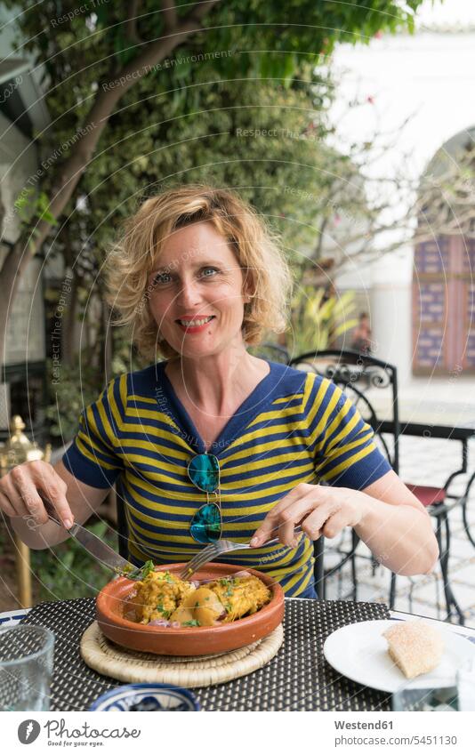 Morocco, portrait of smiling woman eating in a restaurant portraits females women Adults grown-ups grownups adult people persons human being humans human beings