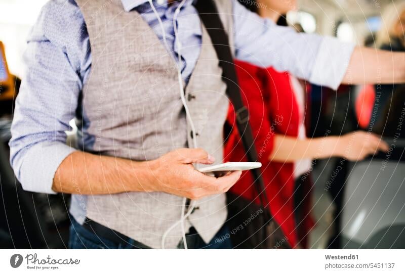 Close-up of businessman using smartphone in tram men males commuter commuters mobile phone mobiles mobile phones Cellphone cell phone cell phones Adults