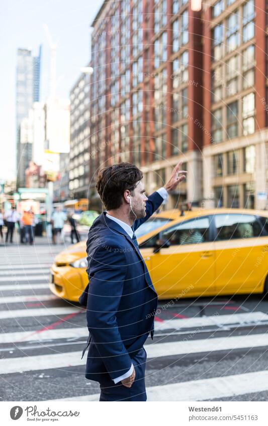 Businessman in the streets of Manhattan hailing a cab attractive beautiful pretty good-looking Attractiveness Handsome waving wave commuter commuters