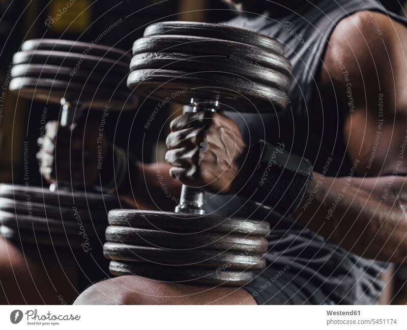 Athlete traing with dumbbells in gym, close up gyms Health Club athlete Sportspeople Sportsman Sportsperson athletes Sportsmen exercising exercise training
